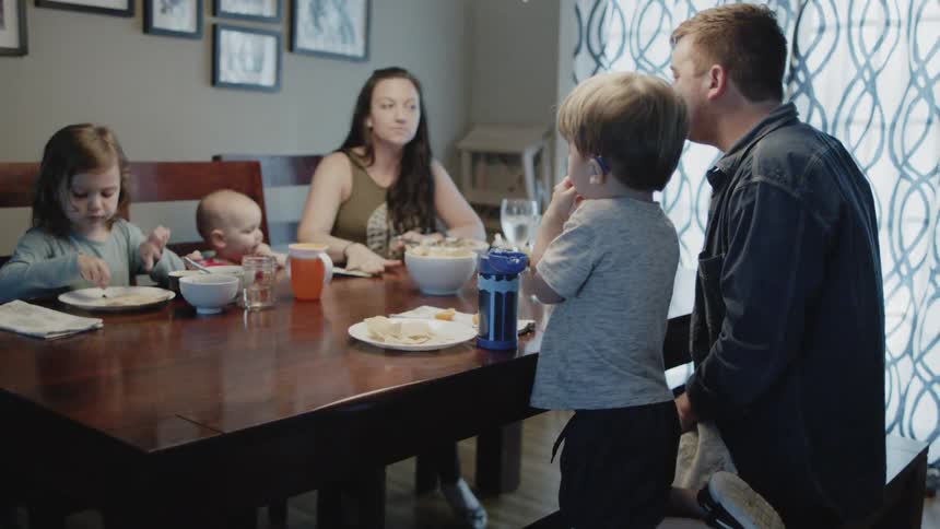 Family sits at the dinner table as they eat