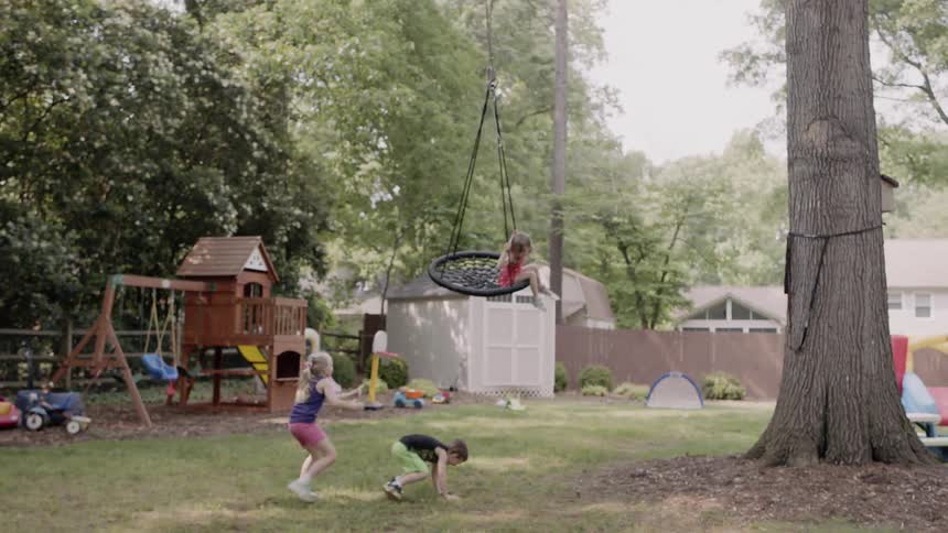 A little girl is sitting on a large swing