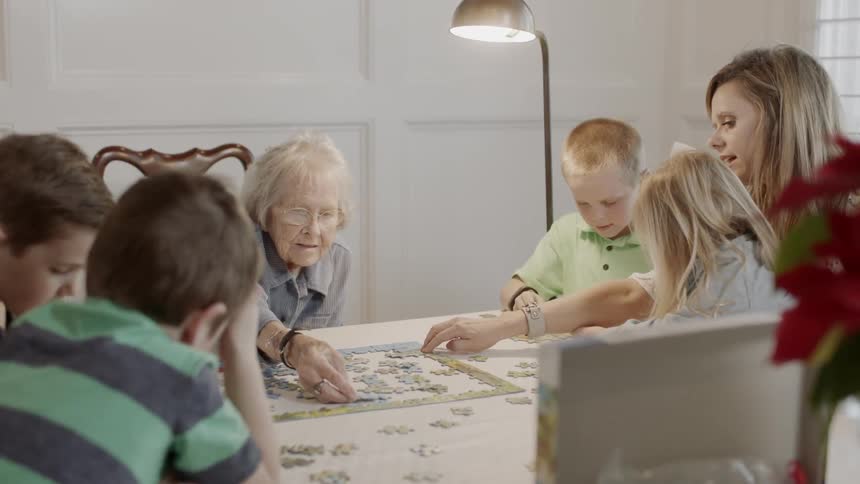 A family does a puzzle at a dining table