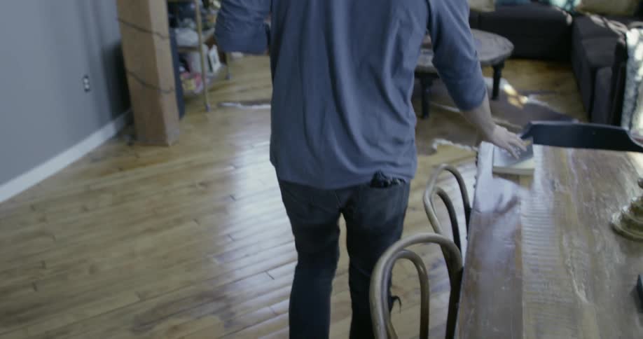 Man picks up a book from a table as he walks by