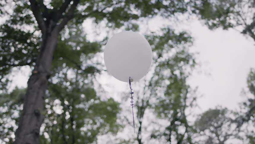 A white balloon is floating in the air