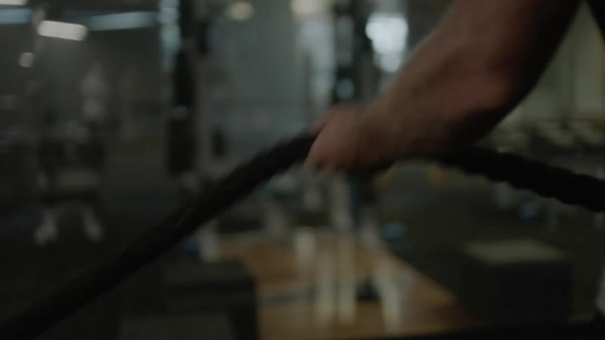 Man exercises with ropes in a gym