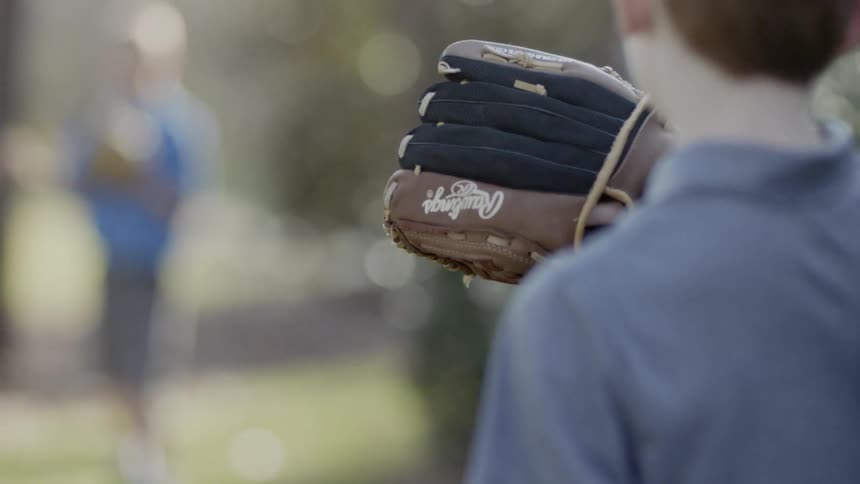 Two people play catch with gloves outside