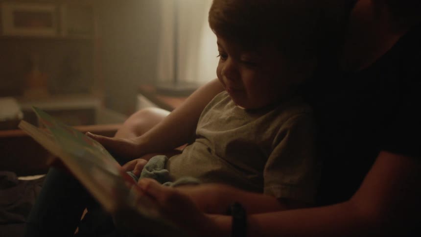Adult reads to a toddler in the evening