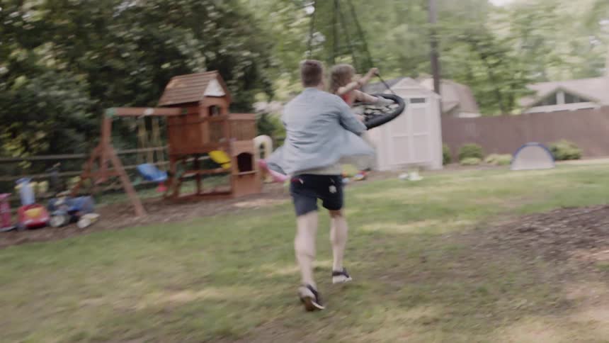 Man pushes girl on a homemade swing