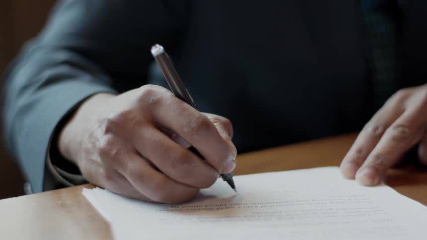 Man writes on a document