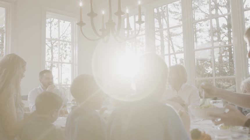 A family sitting in a sunny dining room eating a meal