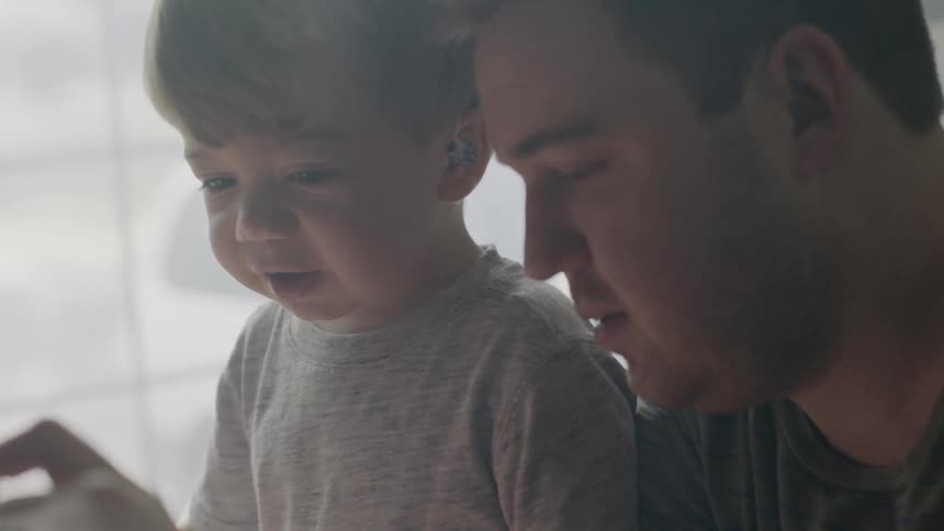Man and toddler boy play at home