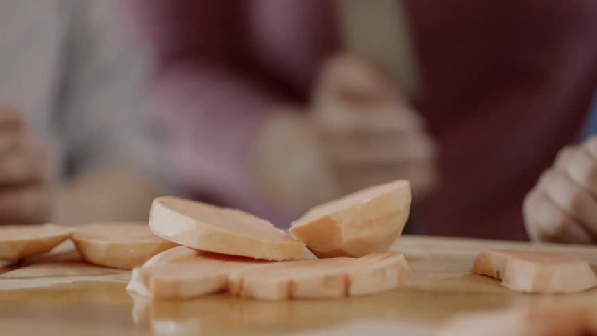 A woman cuts a sweet potato