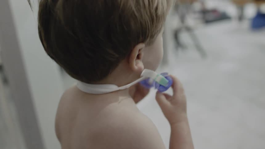 Child puts goggles on outside near a pool