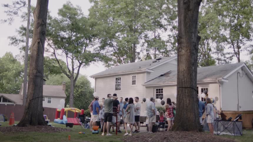 A group of people are having a party in the yard