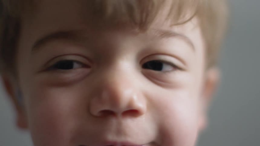 A smiling young boy wears hearing aids