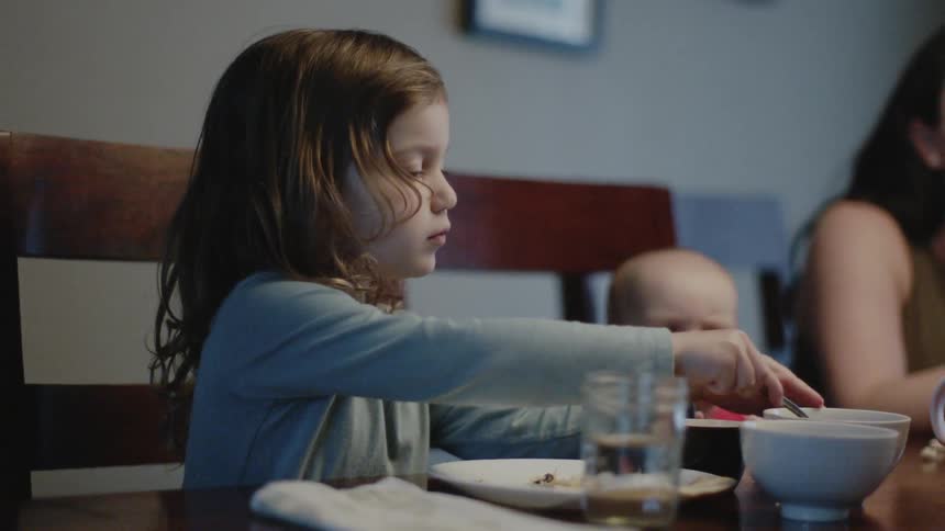 A family dines together at the table./