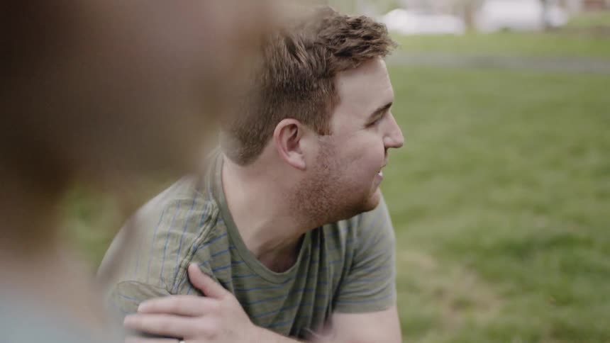 Man and girl talk on a front lawn