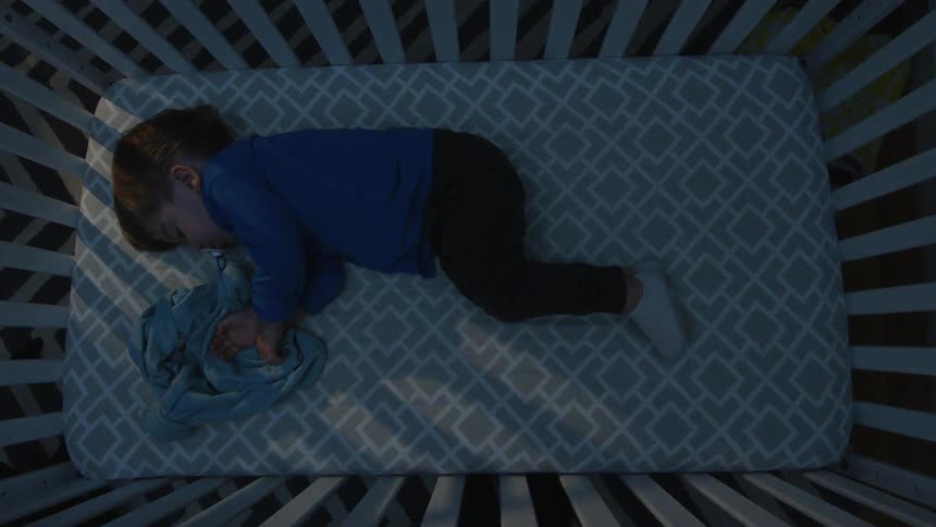 Baby sleeps in a crib and a light turns on