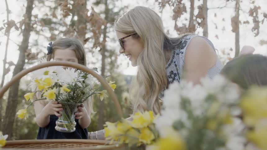 Woman and girls pick flowers in a garden