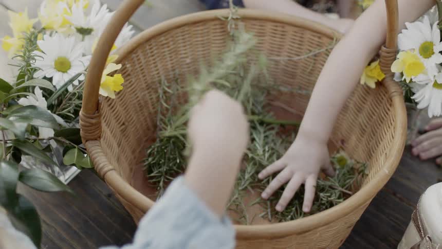 People are arranging flowers in a wicker basket