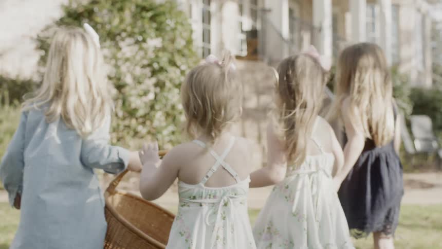 The children walk together carrying a basket