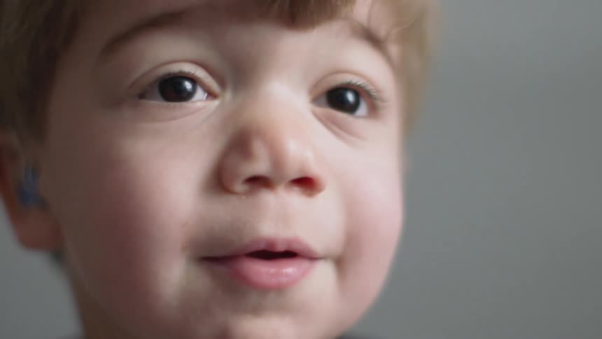 Smiling boy wears hearing aids