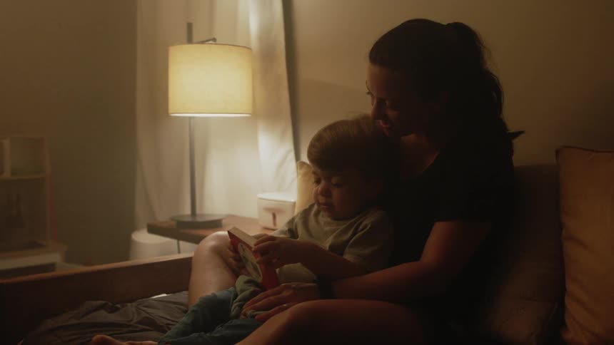 Mom and son read a book at home