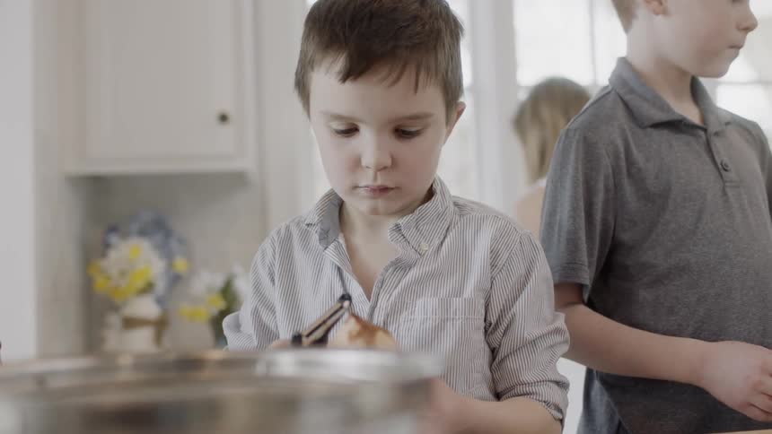 Child peels a potato with a peeler