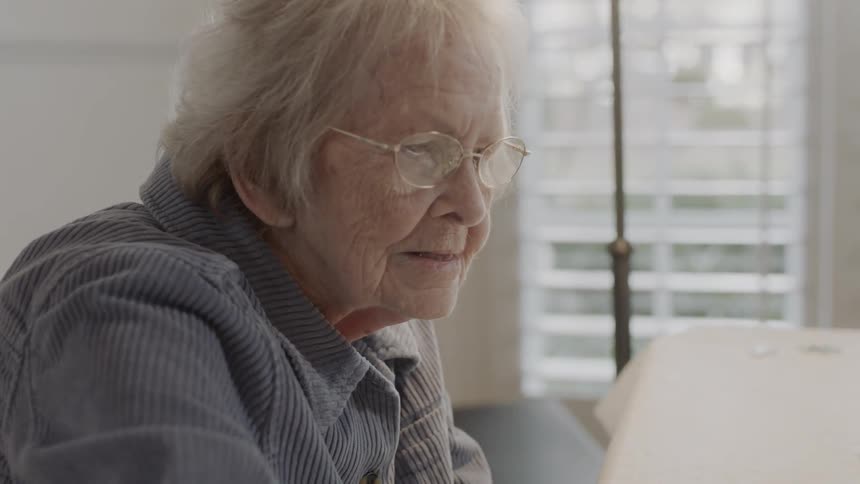 An older woman is sitting and looking at something