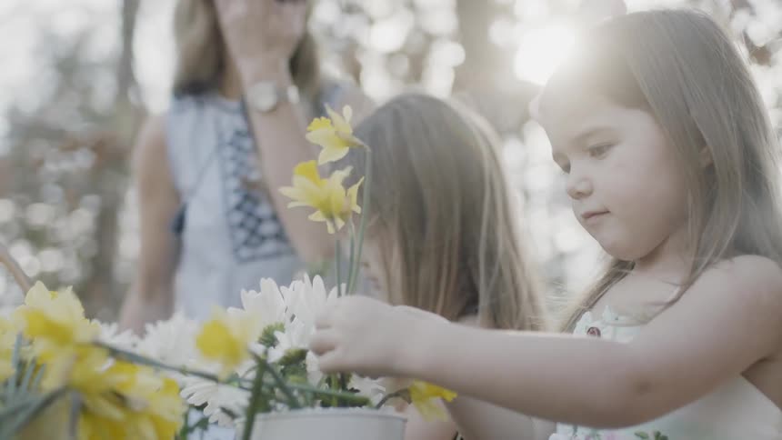 Children help a woman gather flowers together