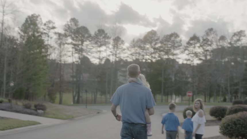 A family walks on a residential street
