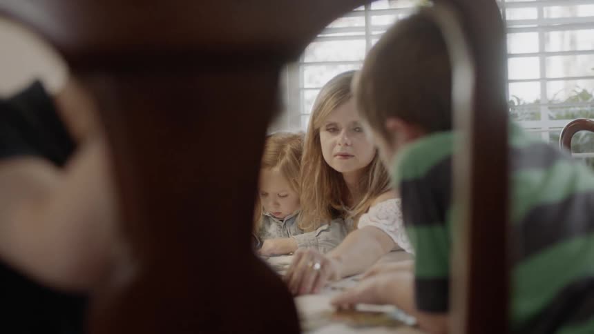 A family does a puzzle at a dining table