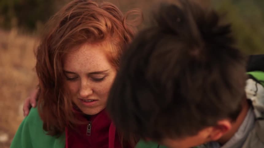 A woman talks with a man on a windy day