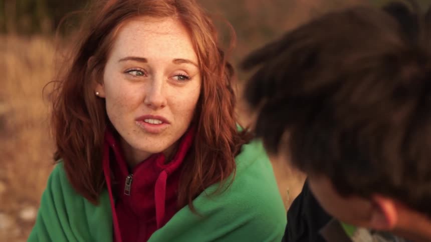Woman talks to another person sitting out