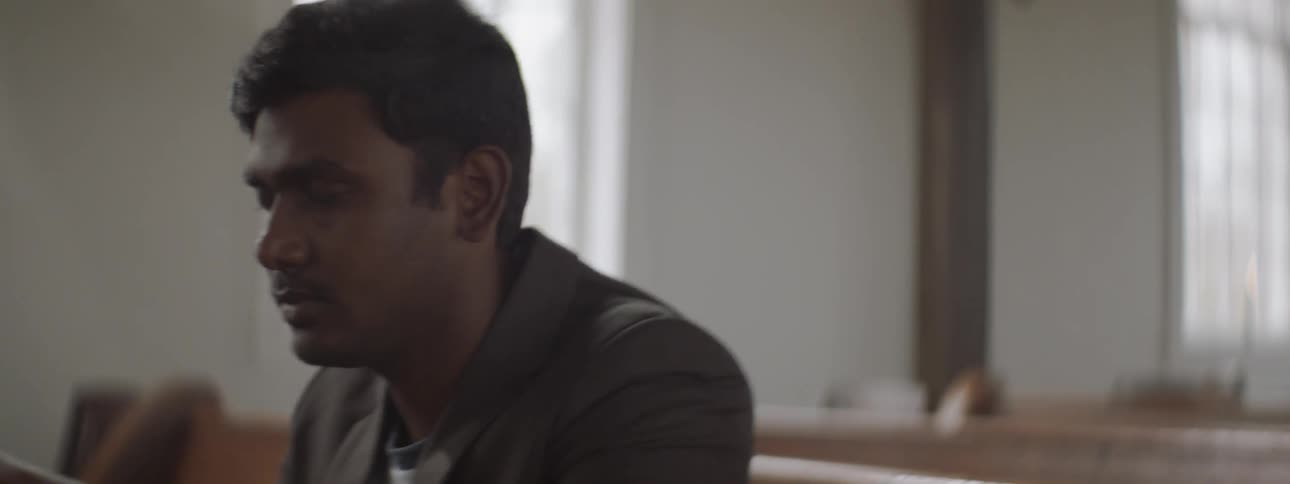 Man leans on a church pew and sits up