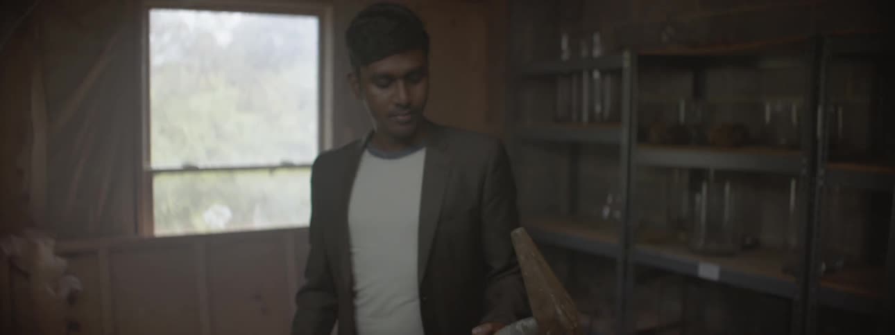 Man standing in a living room holding an ax