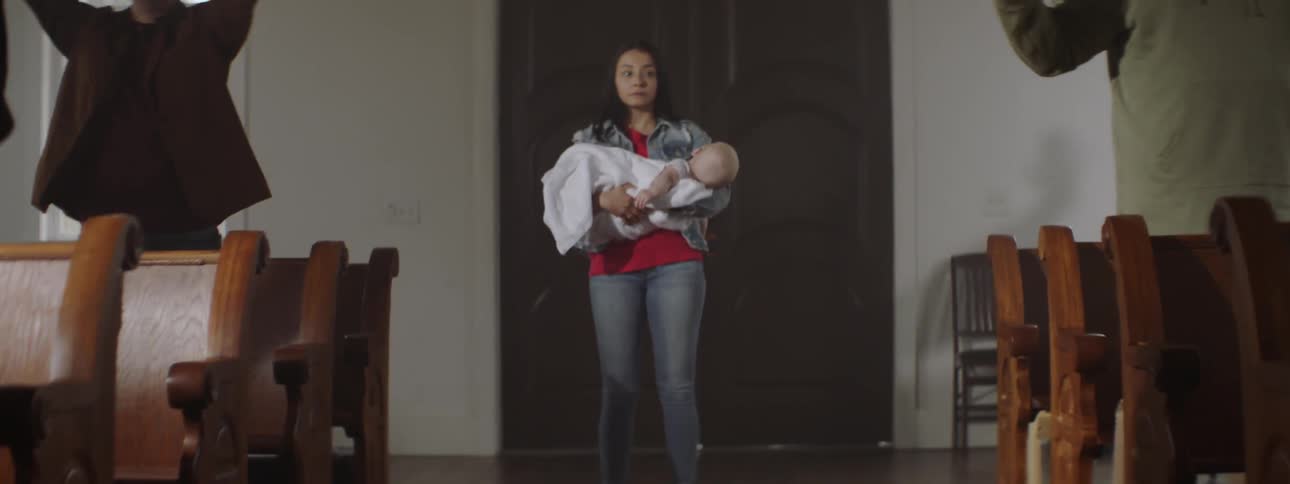 Woman carrying a baby standing in a church