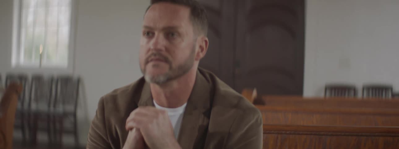 Man sits in a church pew praying