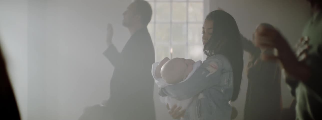 Woman carries a baby through a sunny church