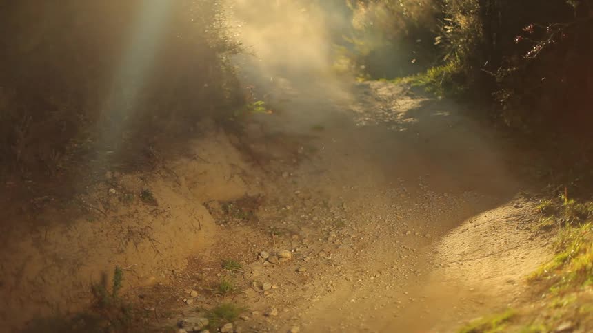 Man riding down a trail downhill on a bike