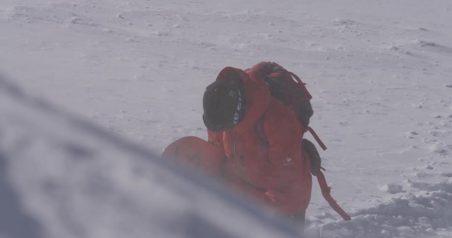 A snowboarder is walking up a hill