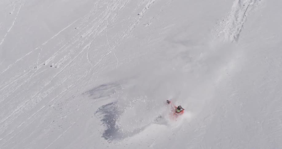 Person does a huge snowboard jump off the top of a snow cliff