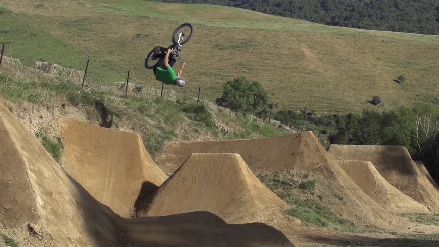 Man riding his bike doing jumps off dirt hills