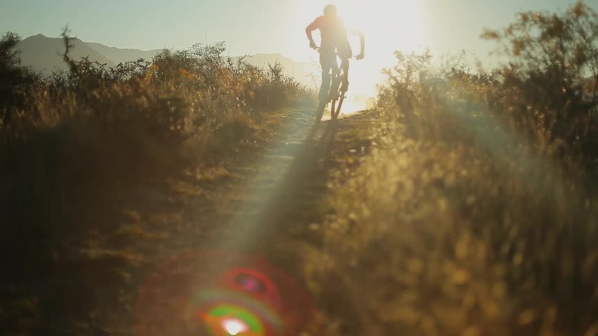 A person rides a dirt bike down a narrow path
