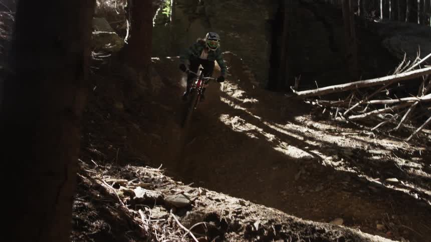 Man riding bike down dirt path through the forest