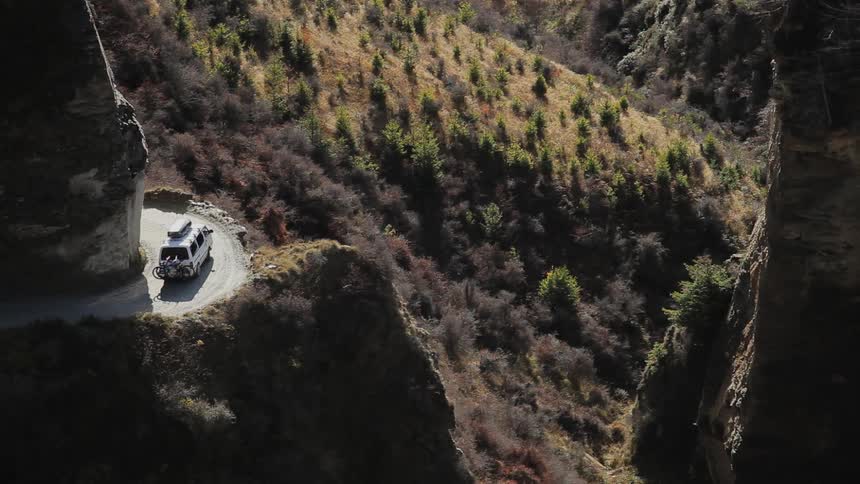 A van driving on a sharply winding mountain road
