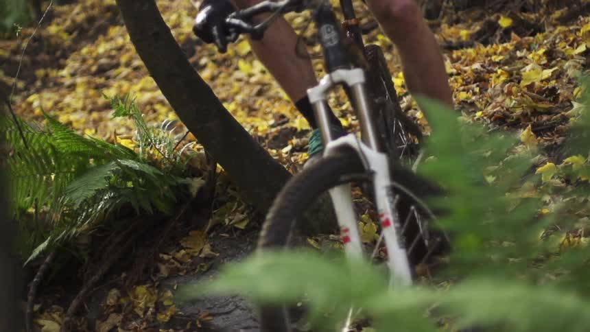 A mountain biker is going down a muddy trail