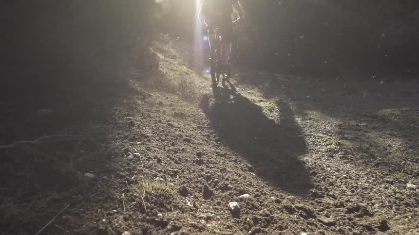 A dirt bike tire skids as the rider turns onto a dirt path
