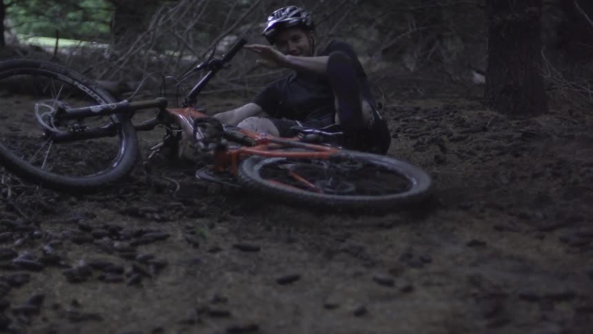 Man riding a bike in the mud and falling