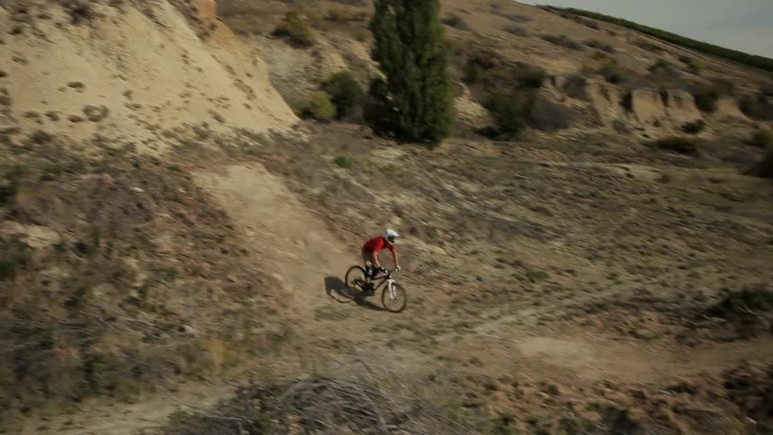 Man riding a bmx bike down dirt hills