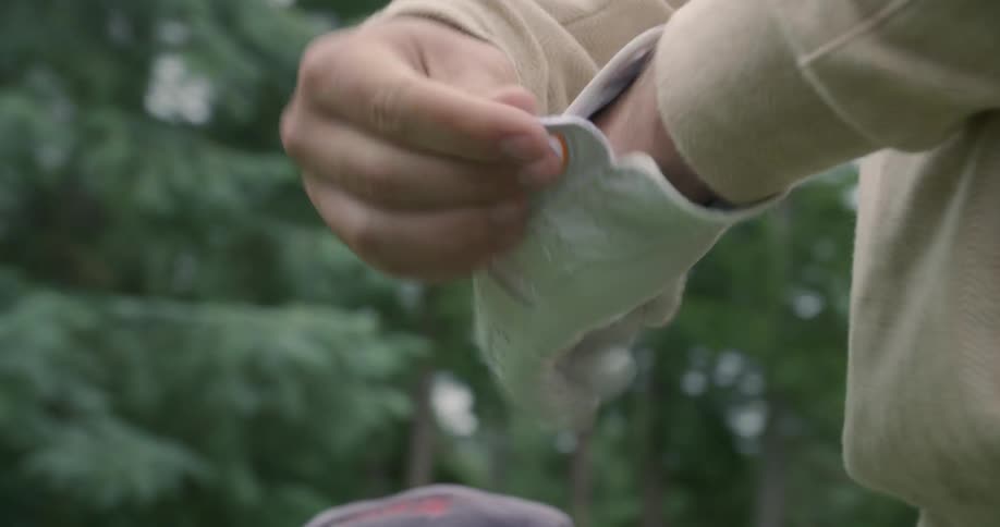 Man puts on a golf glove outside on a golf green