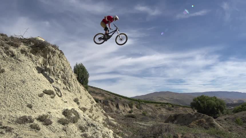 A bicyclist jumping off a steep incline in the desert