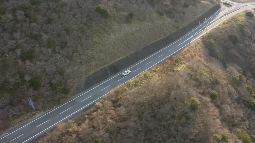 Car drives on a rural mountain road